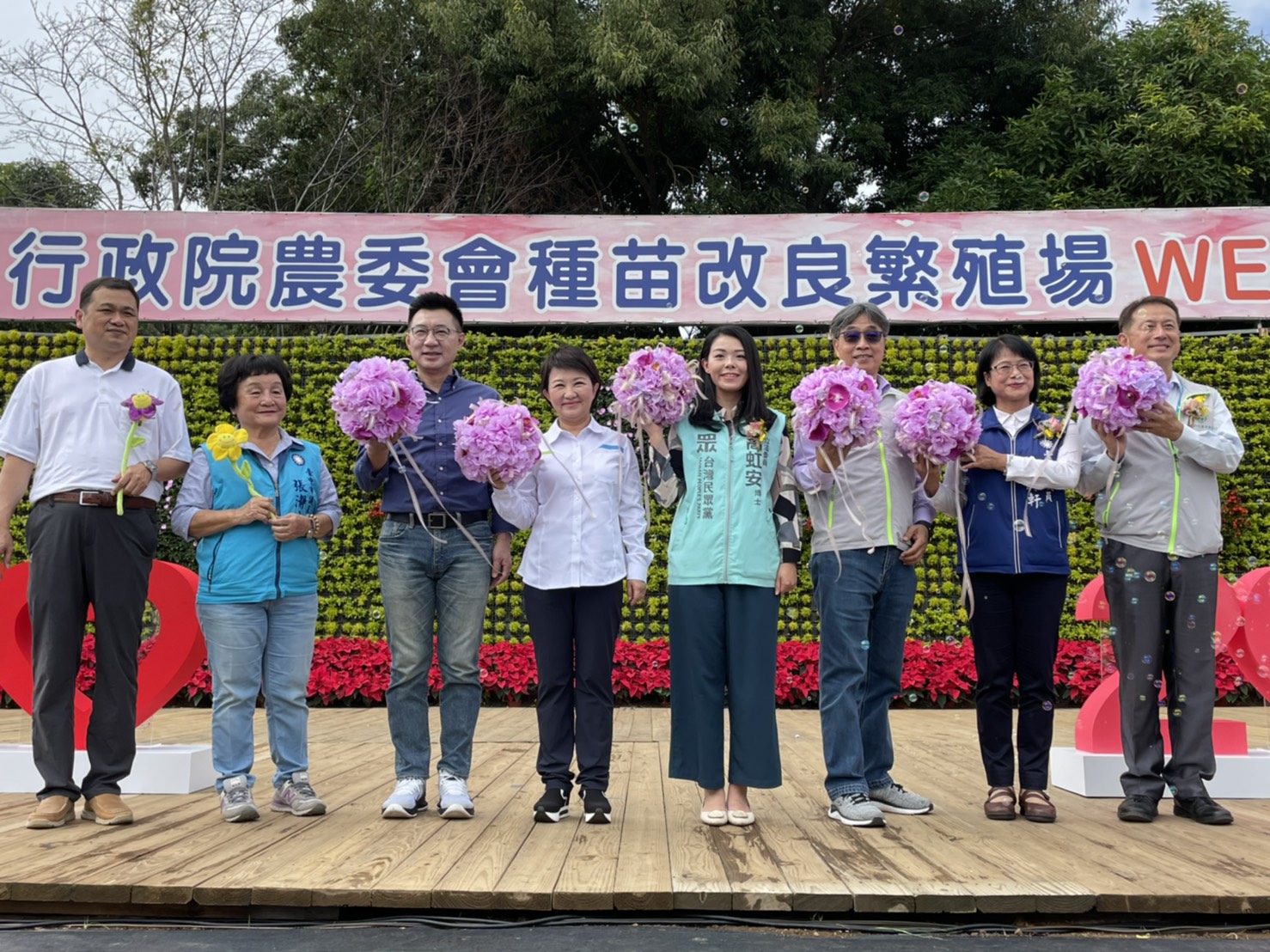 Honored guests hold bouquets of flowers in preparation for the opening ceremony.