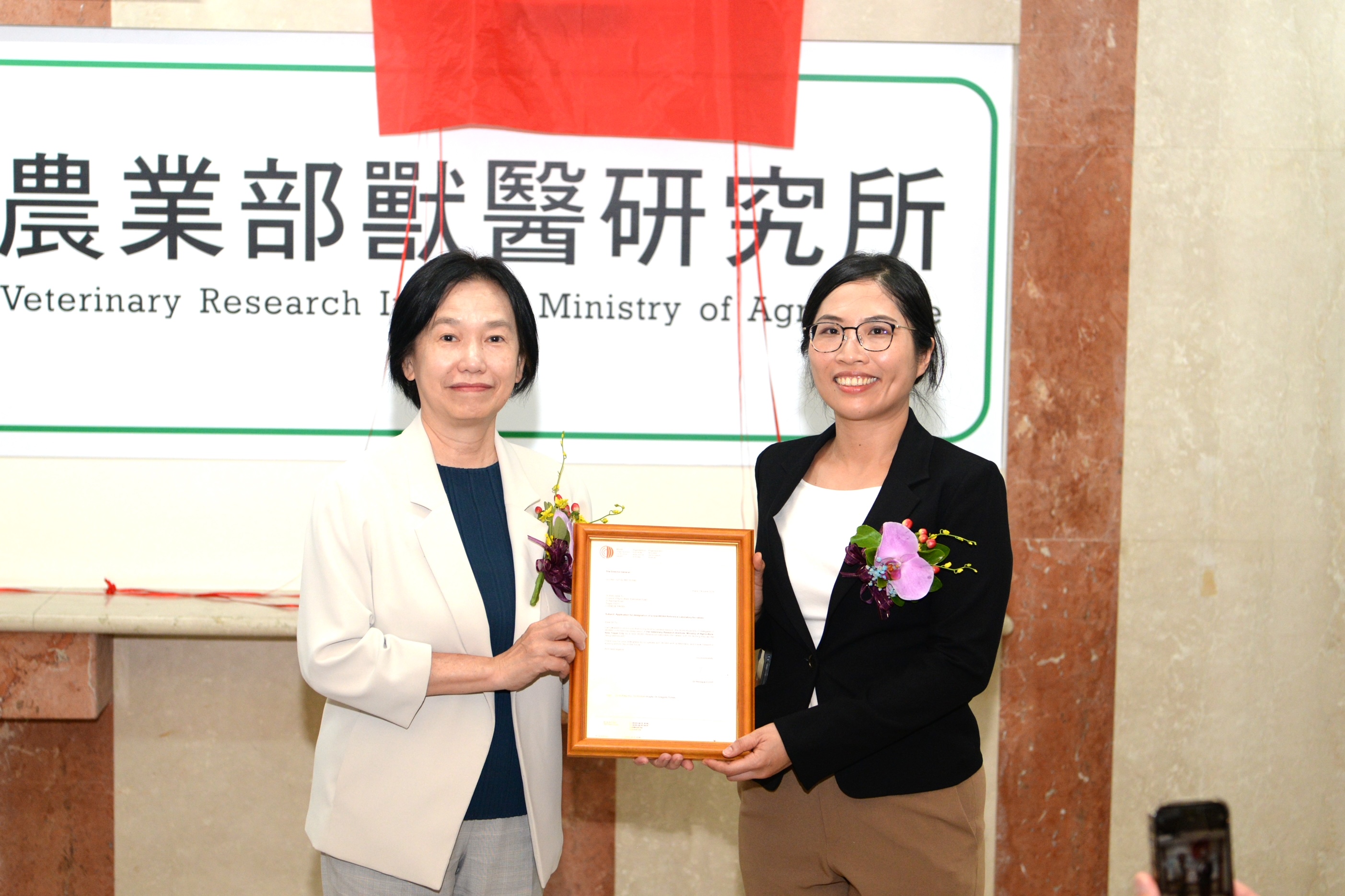 Deputy Minister Tu Wen-janeWen-Jane gives the WOAH certification document to Hsu Ai-Ping.